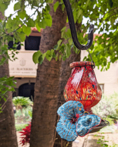 One of Margaret Craig's Setting Seed sculptures rests beside a hanging garden lantern on Blackburn Patio at the McNay Art Museum.