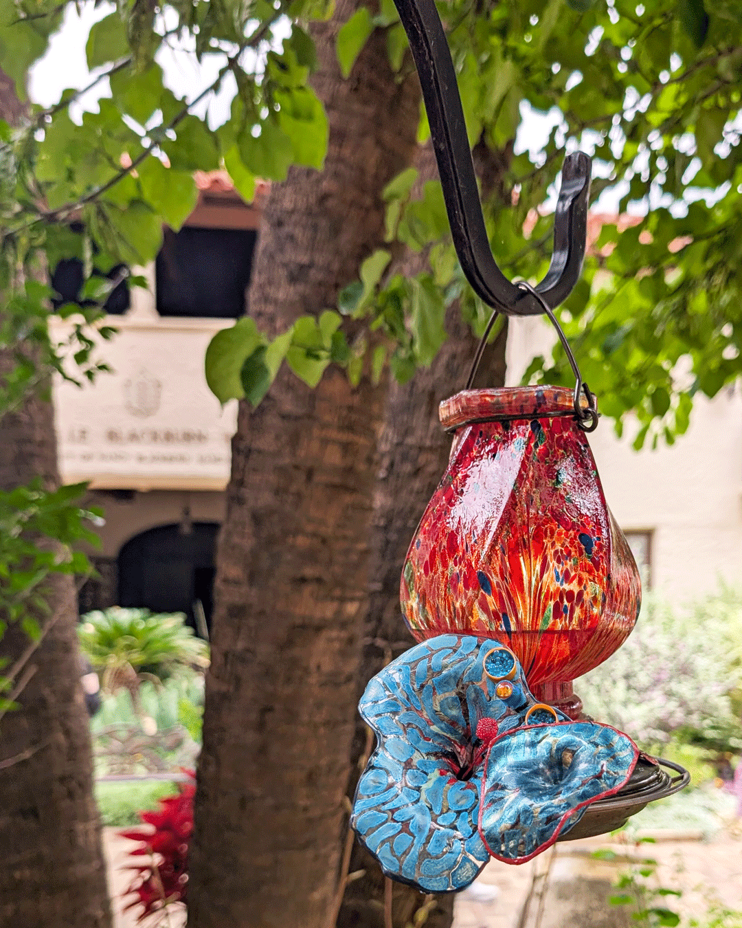 One of Margaret Craig's Setting Seed sculptures rests beside a hanging garden lantern on Blackburn Patio at the McNay Art Museum.