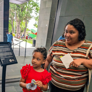 A child and adult learn about Margaret Craig's Setting Seed project during McNay Family Day.