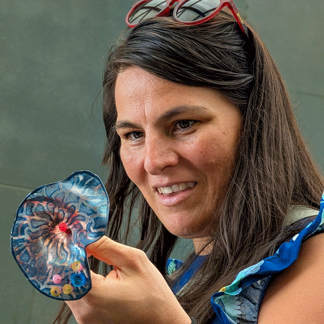 A participant smiles while holding one of Margaret Craig's Setting Seed sculptures.