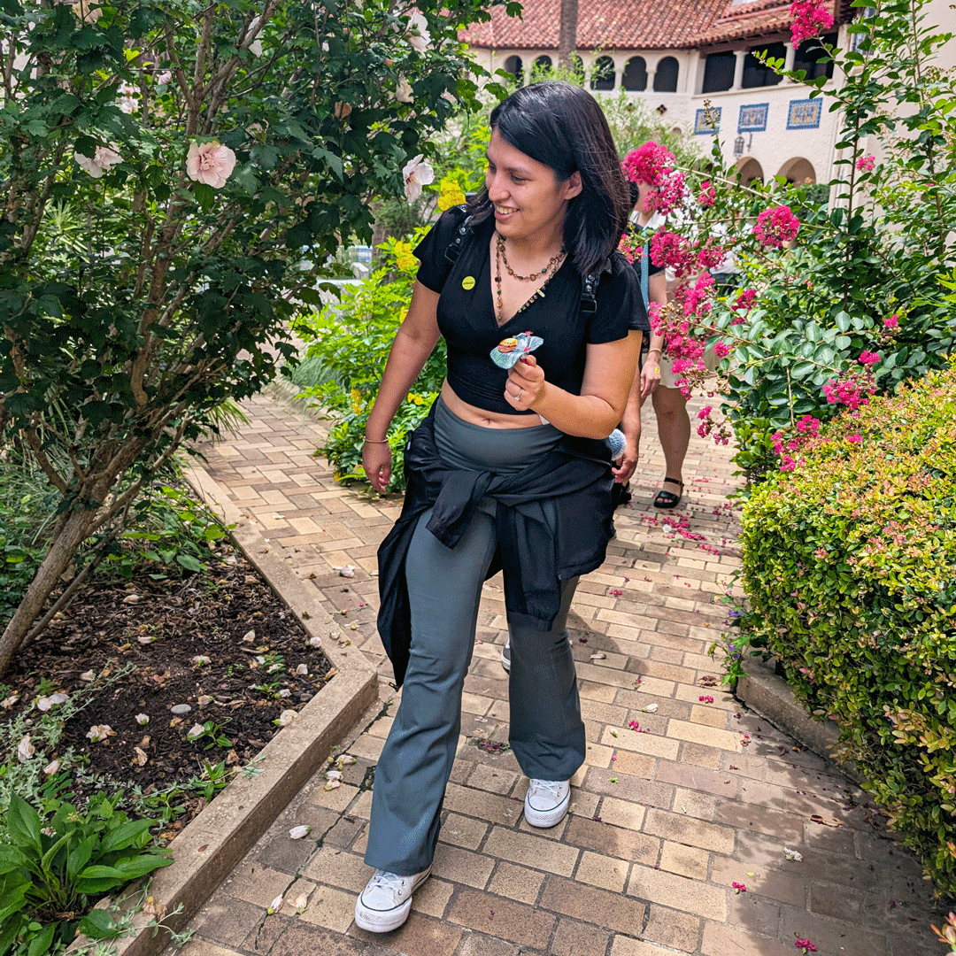 A museum guest carries one of Margaret Craig's Setting Seed sculptures through Blackburn Patio at the McNay Art Museum.